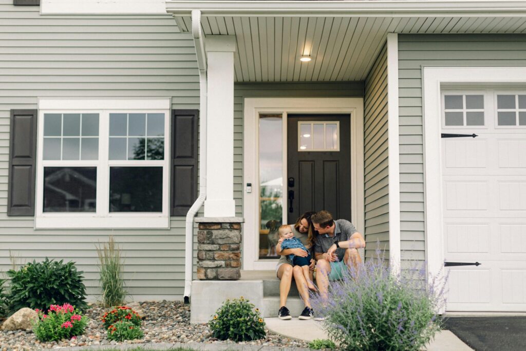 a family sitting in front of a house